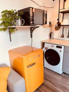 a kitchen with an orange refrigerator next to a microwave at The Room - Direkt in der Stadt! in Bochum +14 photos