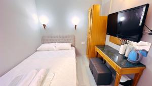 Habitación pequeña con cama y TV. en Taksim Centre Hotel en Estambul