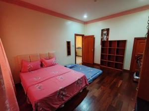 a bedroom with a pink bed in a room at R&S Homestay Sibu - Wedding House with Large Parking Area and High Speed Unifi in Sibu