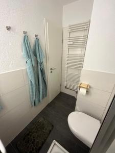 a bathroom with a toilet and blue towels at Ferienwohnung Watt un Leev in direkter Strand & Citynähe von Büsum in Büsum