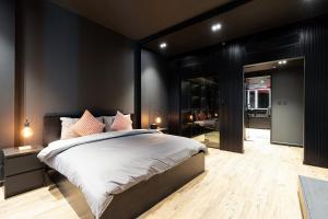 a bedroom with a large bed with black walls at Poetry of the Shadows by Lagom in Dubai