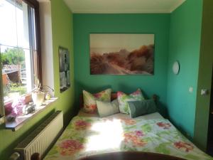 um quarto com uma cama numa parede verde em Ferienwohnung Nordlicht em Großdubrau