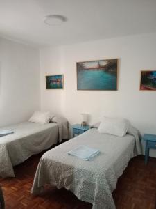 una camera con due letti e due tavoli blu di Apartamento zona Palacio de las Dueñas y las Setas a Siviglia
