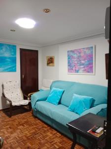 un soggiorno con divano blu e tavolo di Apartamento zona Palacio de las Dueñas y las Setas a Siviglia