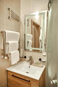 W łazience znajduje się umywalka, lustro i ręczniki. w obiekcie Готель Зірка w mieście Kropywnycki