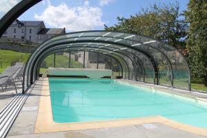 ein Schwimmbad mit einer Glasbrücke darüber in der Unterkunft Le Grenier de la Floye - Gîte Coquelicot in Mettet