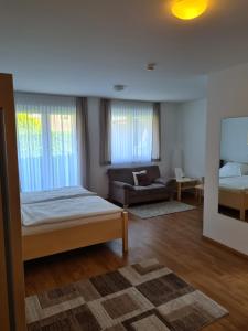 ein Schlafzimmer mit einem Bett und einem Sofa in einem Zimmer in der Unterkunft Hotel Am Wintergarten in Bocholt