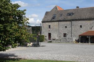 ein großes Steingebäude mit einem Tor davor in der Unterkunft Le Grenier de la Floye - Gîte Coquelicot in Mettet