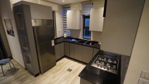 a kitchen with a stainless steel refrigerator and wooden floors at Hero's Chalet - Deadsea in Al Rama