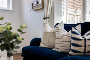 a blue couch with pillows on it in a living room at Hidden Gem Hideaway w/ Free Parking in Hough Green