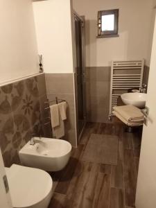 ein Badezimmer mit zwei Waschbecken, einem WC und einer Dusche in der Unterkunft b&b La Divina Pietra 
