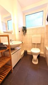 Łazienka z białą toaletą i umywalką w obiekcie Perfect Apartment in Unna close to Dortmund w mieście Unna