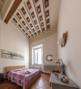 a bedroom with a bed and a desk and a window at Fabroniana apartment Elegant in Pistoia