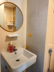 a bathroom with a white sink and a mirror at ITCC Manhattan Suites by Pleasant Amenities in Donggongon