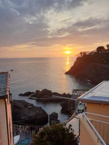 een zonsondergang boven de oceaan met een groep mensen bij Hotel Marina Piccola in Manarola