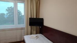 a room with a bed with a tv on the wall at Noclegi Gambit Cieszyn 24h in Cieszyn