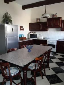 uma cozinha com uma mesa com cadeiras e um frigorífico em Villa Palma em Sannat