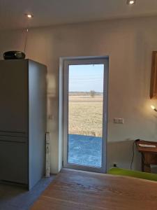 um quarto com uma porta com vista para um campo em Cosy house with a big garden in the countryside em Gołaszewo