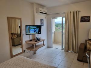 sala de estar con TV y espejo en Flat 606 Golden Dolphin Express, en Caldas Novas