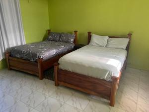 two beds sitting next to each other in a room at Oneworld Guesthouse & and Events Centre in Accra