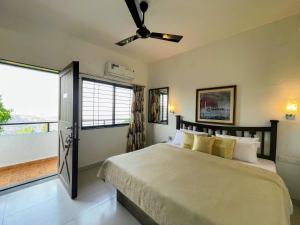 a bedroom with a bed and a large window at The Loft in Panchgani