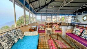 a room with couches and chairs and a table at The Loft in Panchgani
