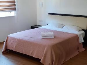 Una cama blanca con una toalla encima. en Villa Larnaca Bay Resort, en Oroklini