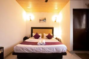 a bedroom with a bed with two shoes on it at PerfectPlus Mussoorie in Mussoorie