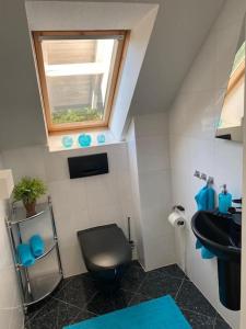 ein Bad mit einem schwarzen WC und einem Waschbecken in der Unterkunft Residenz Jäger in Lohfelden