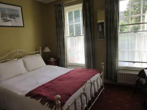 een slaapkamer met een bed met een rode deken erop bij Cathedral Cottage in Derry Londonderry