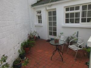 a patio with two chairs and a table and some plants at Cathedral Cottage in Derry Londonderry
