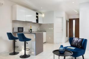 a kitchen with two blue chairs and a counter at Studio Apartman Nega 3 in Rovinj