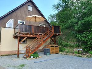 a house with a deck with an umbrella at Ferienwohnung Naturpark Schwarzwald in Löffingen