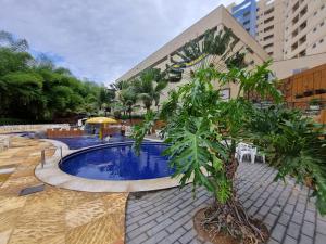 una piscina con árboles frente a un edificio en Flat 606 Golden Dolphin Express en Caldas Novas