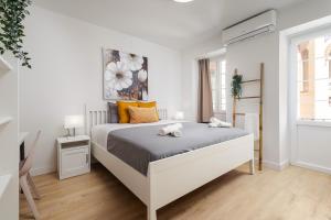 a white bedroom with a bed with two towels on it at Nordik Rooms Urban - Centro "Estocolmo" in Málaga