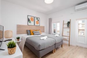 a white bedroom with a large bed and a desk at Nordik Rooms Urban - Centro "Estocolmo" in Málaga