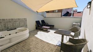 a bathroom with a tub and a table and chairs at Hotel Boutique Adealba Badajoz in Badajoz