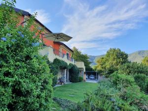 a house with a green yard next to a building at Villa Claudia in Quiliano