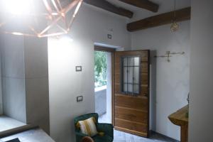 a hallway with a wooden door and a green chair at Vicolo d'Este in Tivoli