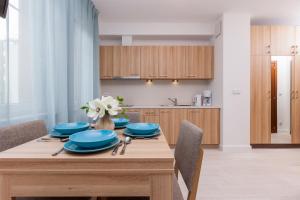 a dining room table with blue dishes on it at Apartamenty Aquamarina by Renters in Świnoujście