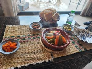 - une table avec des bols de nourriture et de légumes dans l'établissement Dardiyafa, à Azrou