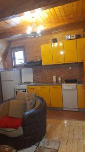 una cocina con armarios amarillos y un sofá en una habitación en Odmor, en Šavnik