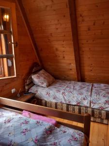 a bedroom with two beds in a wooden cabin at Odmor in Šavnik