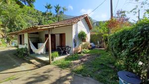 a small house with a hammock outside of it at Canto do Riacho Chales in Trindade