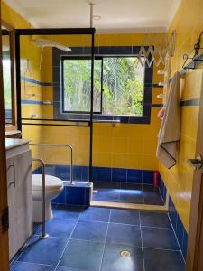 een gele badkamer met een wastafel en een toilet bij Casa de campo Cutucumay in Chinauta