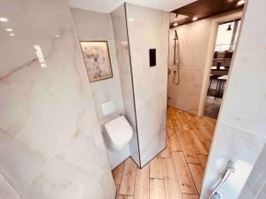 uma casa de banho branca com um WC e um chuveiro em Luxus Loft im Herzen von Bochum Werne. em Bochum
