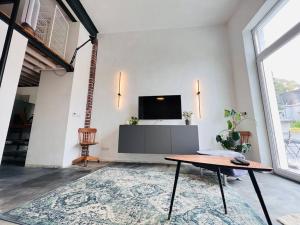 a living room with a tv and a table at Luxus Loft im Herzen von Bochum Werne. in Bochum