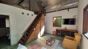 a living room with a staircase and a television at Canto do Riacho Chales in Trindade