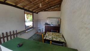 a room with a green table and a kitchen at Canto do Riacho Chales in Trindade