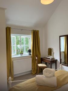 a bedroom with a bed and a desk and a window at Mews house in the centre of Henley-on-Thames in Henley on Thames